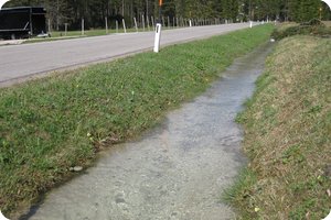 Neben der Straße fließt es nach Westen ab