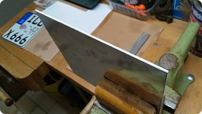 Das Blech im Schraubstock (mit Schutzbacken aus Holz)